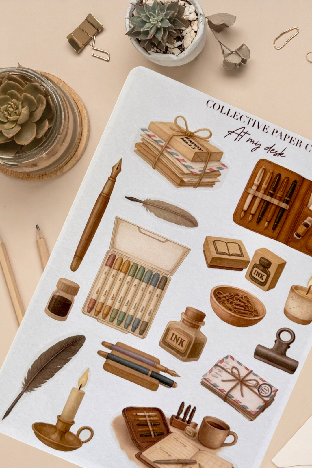 Sticker sheet with stationery items on a beige surface with plants and office supplies.