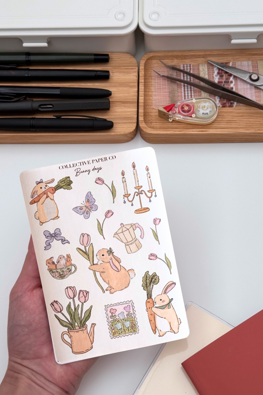 Bunny days sticker sheet with soft crayon style illustrations of rabbits, tulips, butterflies, candlestick, coffee pot, teacup with bunnies and a spring garden postage stamp from Collective Paper Co