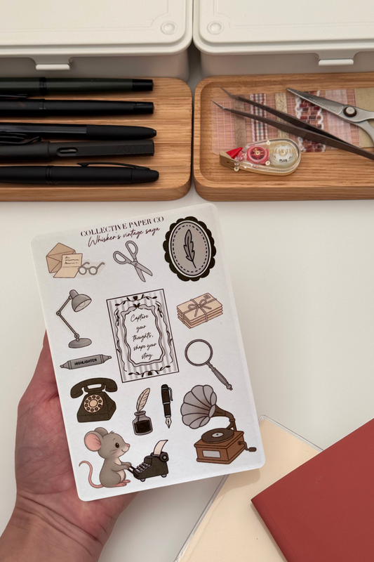 Sheet of vintage-themed stamps held by a hand with stationery items in the background.