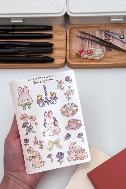 Bunny daydreams sticker sheet with pastel crayon style illustrations of bunnies, flowers, chandelier, heart cookies, floral teacup and a yellow bow in soft dreamy colours from Collective Paper Co