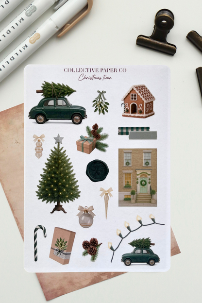 Collection of Christmas-themed stickers on a white card with stationery items around.