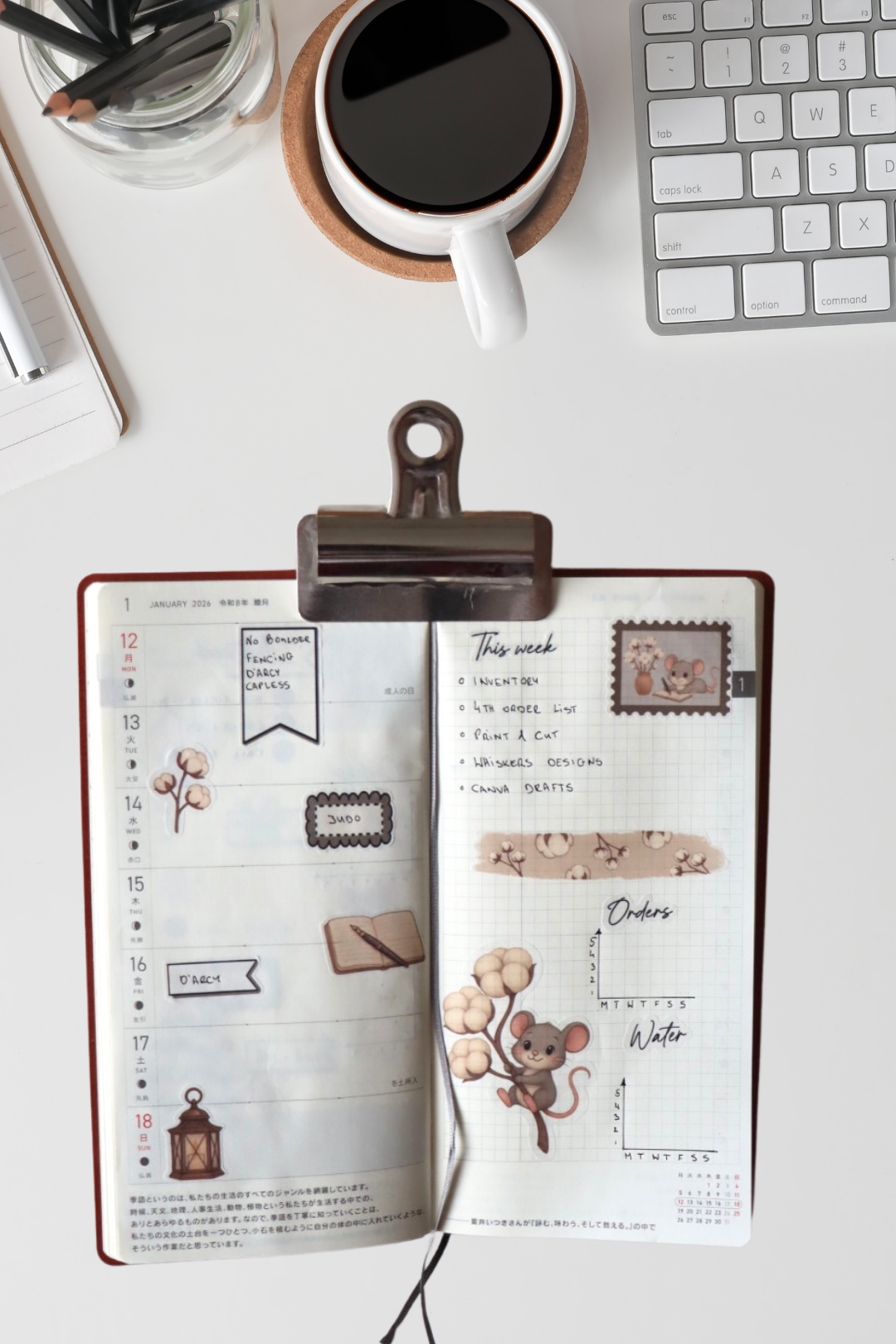 Open planner with decorative pages on a desk with a coffee cup and keyboard.