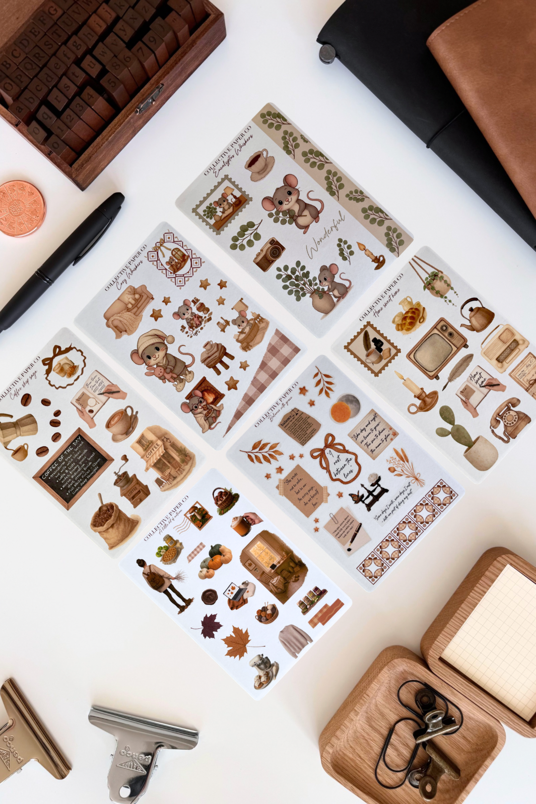 Collection of decorative stickers with nature-themed designs on a white surface with stationery items.