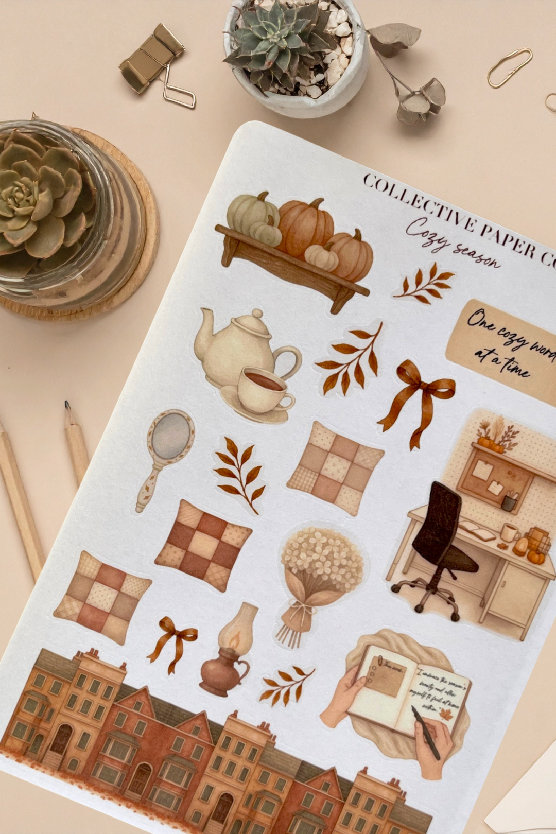Sticker sheet with autumn-themed designs on a beige surface with decorative items.