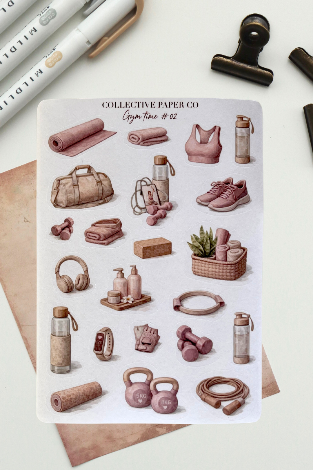 Sheet of fitness-themed stickers by Collective Paper Co. on a white surface with stationery items.