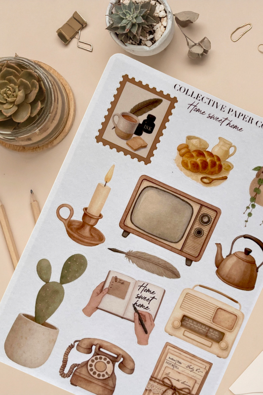 Sticker sheet with vintage-themed illustrations on a beige surface with plants and stationery items.