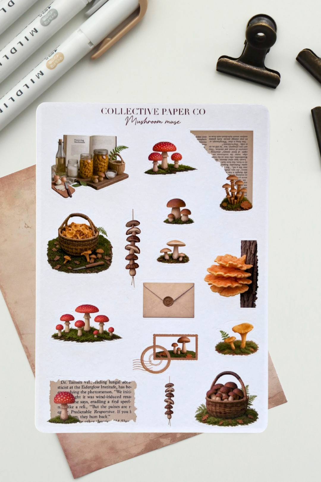 Sheet of mushroom-themed stickers by Collective Paper Co on a white background with stationery items.
