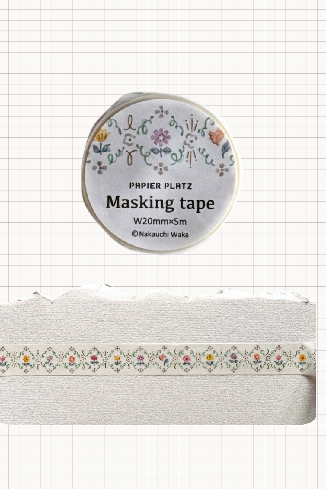 Papier Platz floral masking tape roll featuring a repeating border of tiny multicoloured flowers and leaves on cream tape, shown on grid background with a swatch of the 20 mm wide 5 m tape unrolled