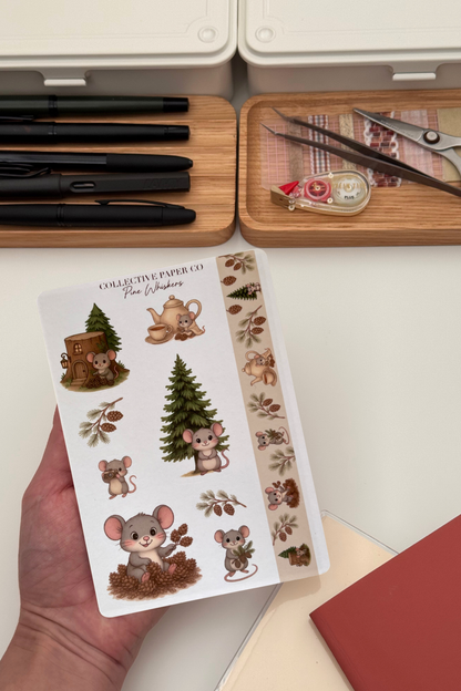 Sheet of decorative stickers featuring mice and nature-themed illustrations held by a hand, with stationery items in the background.