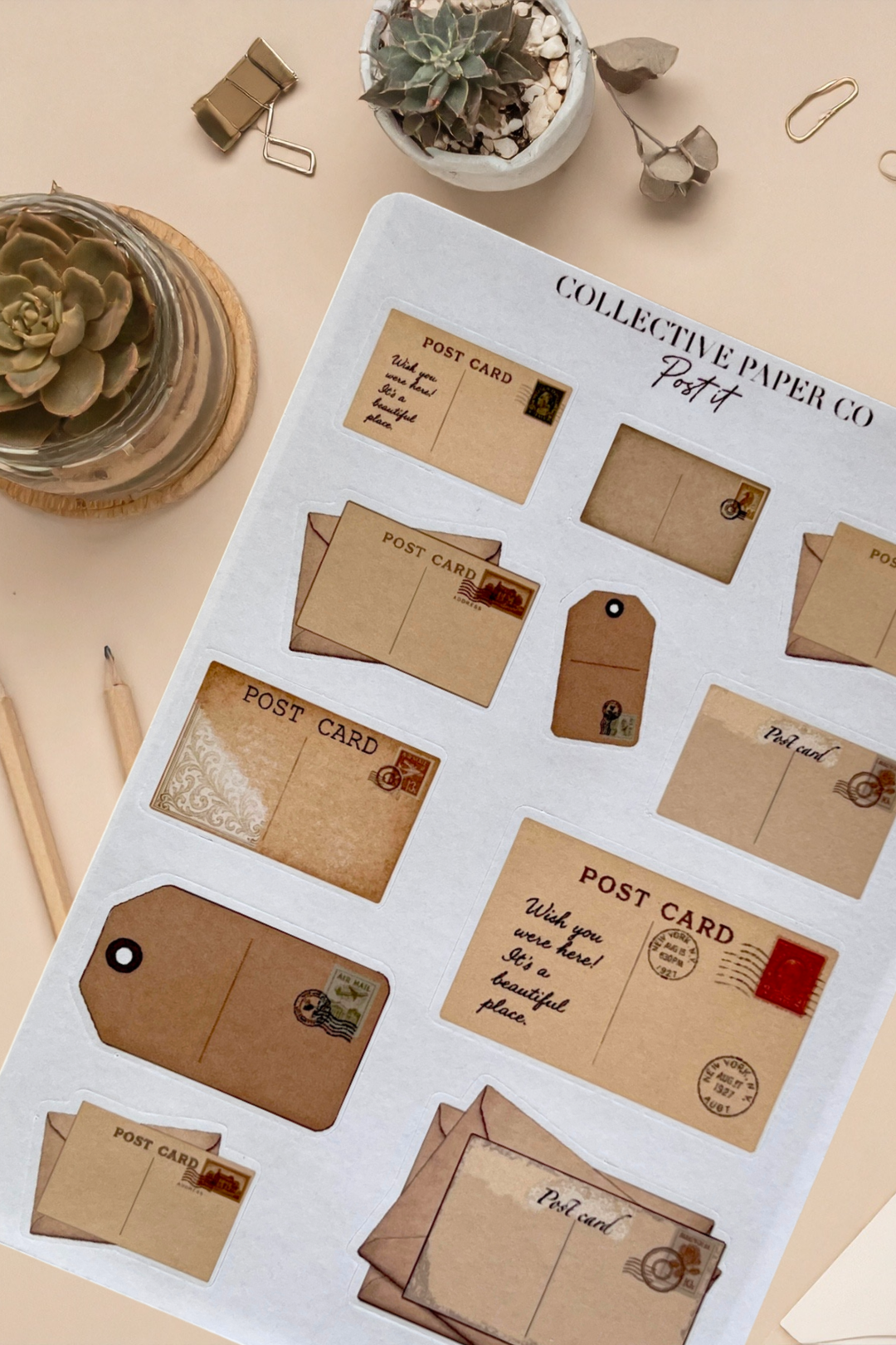 Sheet of vintage-style paper products including postcards and envelopes on a light surface with decorative items.