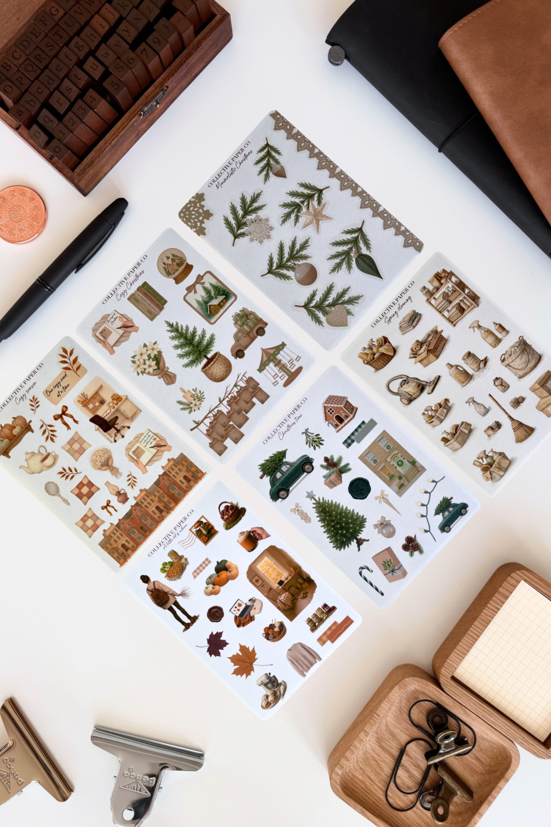 Set of decorative stamps on a white surface with a pen and other items.