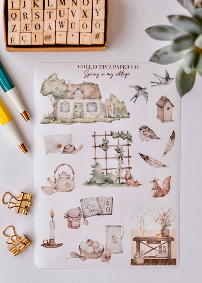 Collective Paper Co.'s Spring in My Village washi tape features watercolor cottages, birds, snails, teapots, and lanterns, styled with stamps, pens, clips, and a succulent.
​

