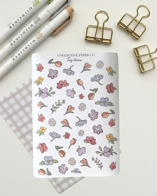 Collective Blooms Co. sticker sheet featuring scattered watercolor-style spring flowers in pink, purple, orange, and white, including tulips, daisies, and violets on a white background.
