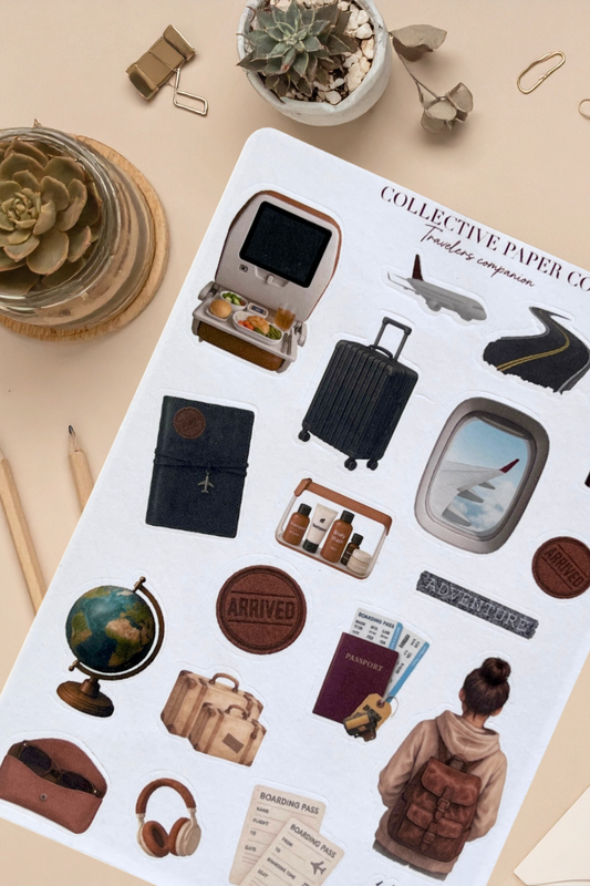 Collection of travel-themed stickers on a paper sheet with stationery items around.