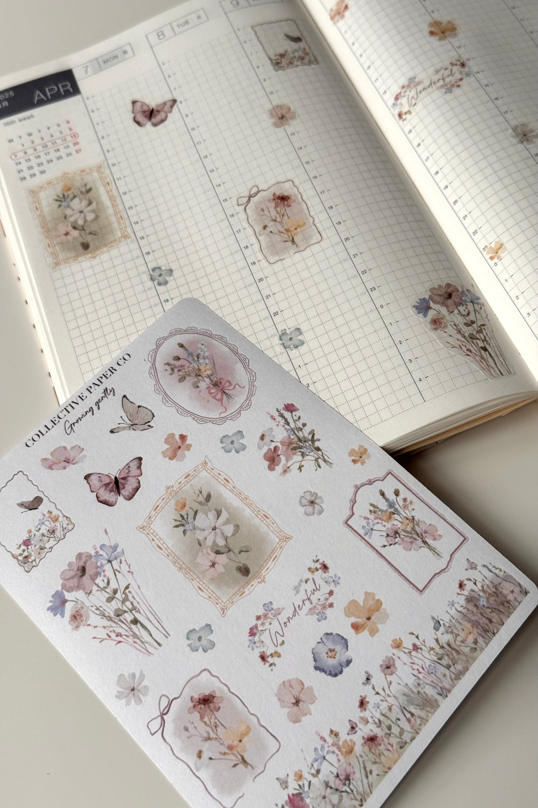 Growing gently sticker sheet with soft botanical illustrations, butterflies and plant themed icons on journal pages, close up